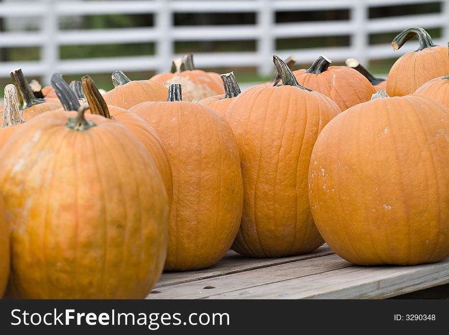 A collection of pumpkins sitting on wooden wagon - for sale. A collection of pumpkins sitting on wooden wagon - for sale.