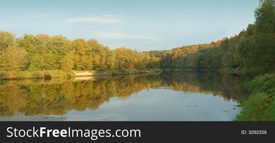 Scene of autumn forest at the river