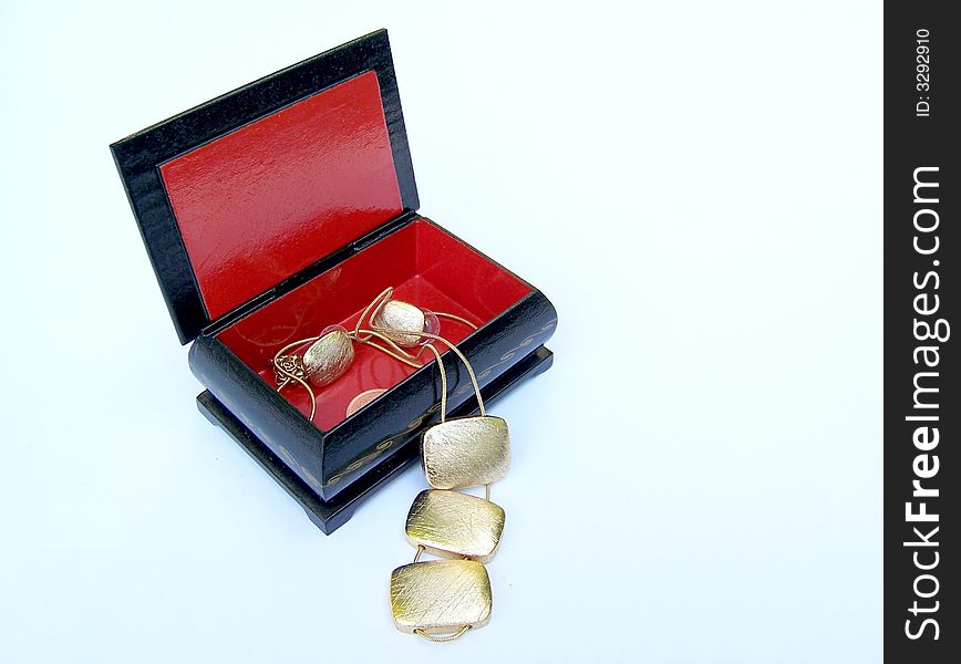 The gold pendant and earrings in the box. The gold pendant and earrings in the box