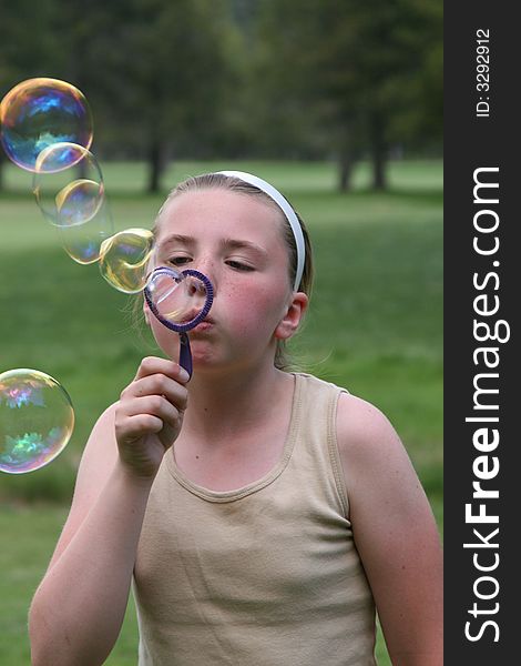 Little teen girl blowing bubbles.