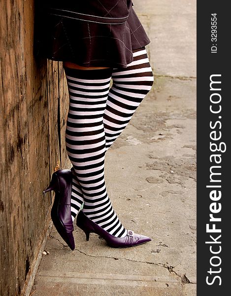 Womans legs in heels and striped stockings