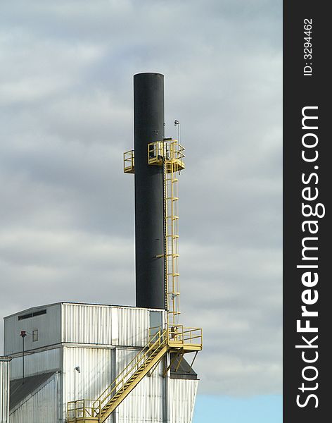 A smokestack that puts out steam from an energy generating facility. A smokestack that puts out steam from an energy generating facility