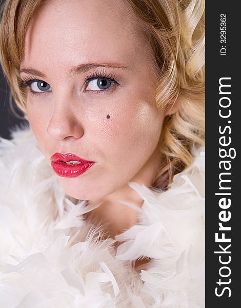 Close up portrait of blonde woman with red lips and feathers