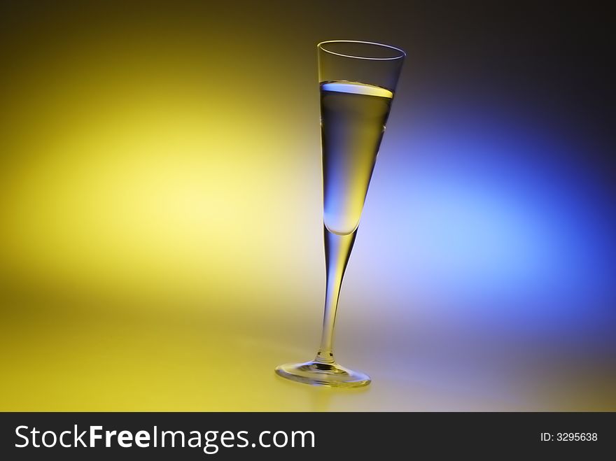 A thin glass filled with water with colorful background. A thin glass filled with water with colorful background