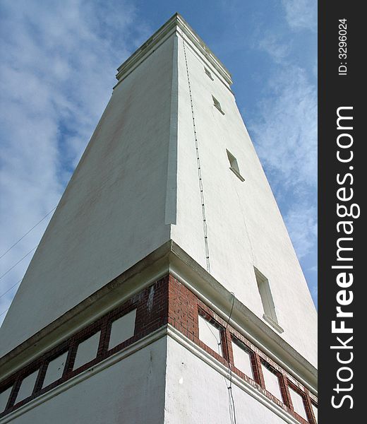 Perspective view of a tall white lighthouse