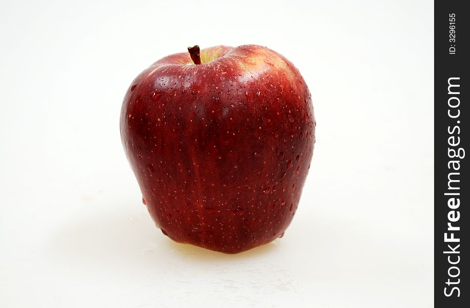 Big red apple with drops on white background