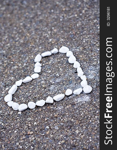 Small white stones heartshaped lying on the street.