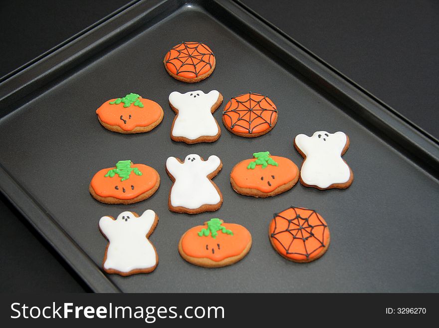 Ghosts,pumpkin and spiders web Gingerbread biscuits on a baking tray for halloween party. Ghosts,pumpkin and spiders web Gingerbread biscuits on a baking tray for halloween party