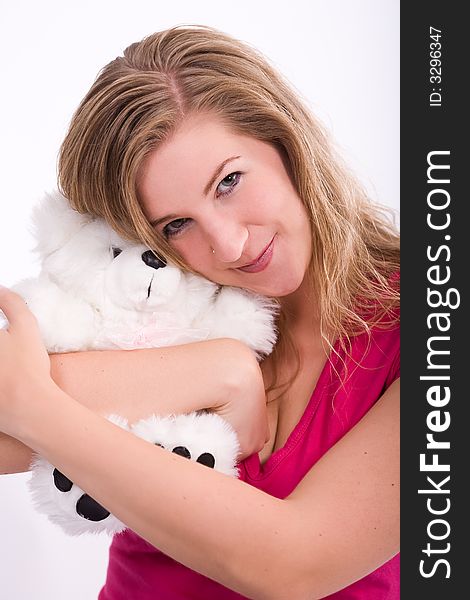 Young woman hugs her teddy bear and presses her head on him. Obviously happy while doing this. Young woman hugs her teddy bear and presses her head on him. Obviously happy while doing this.