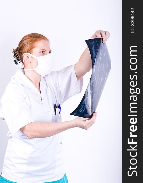 Redhaired woman doctor (or nurse) examines X-ray. White background. Redhaired woman doctor (or nurse) examines X-ray. White background.