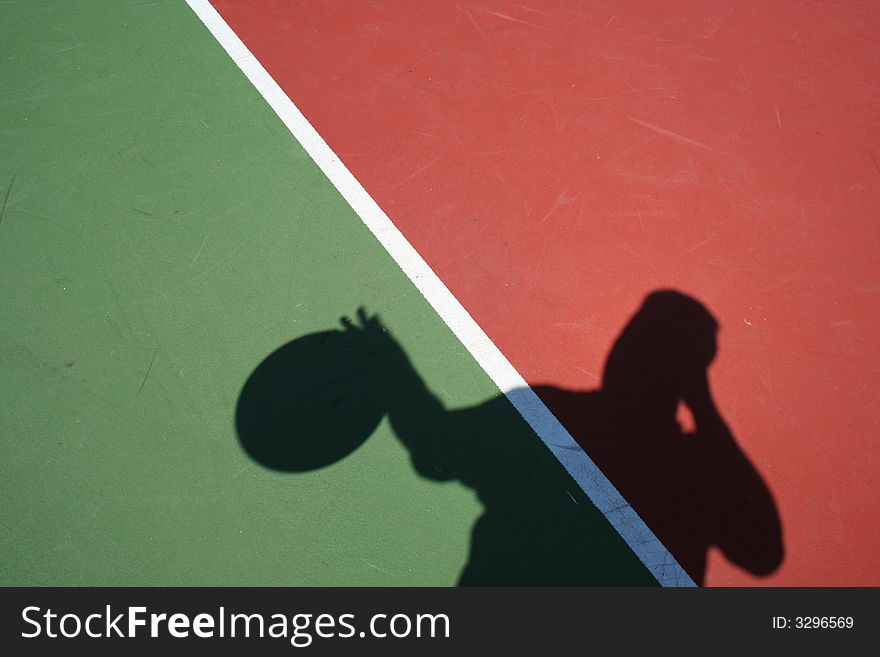 A Basketball shadow player dribbling on red and green court