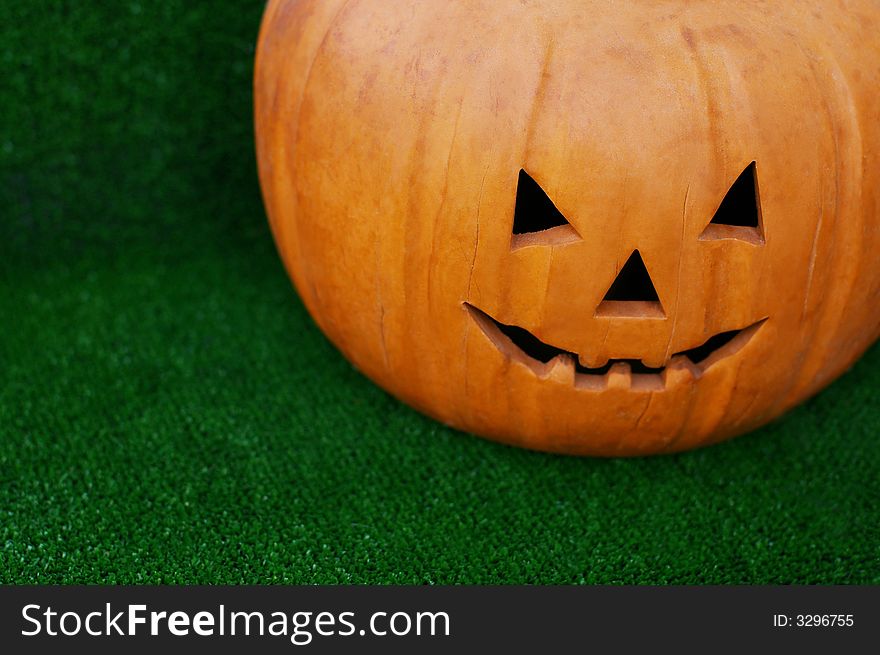 Pumpkin with the cut out person on a green grass