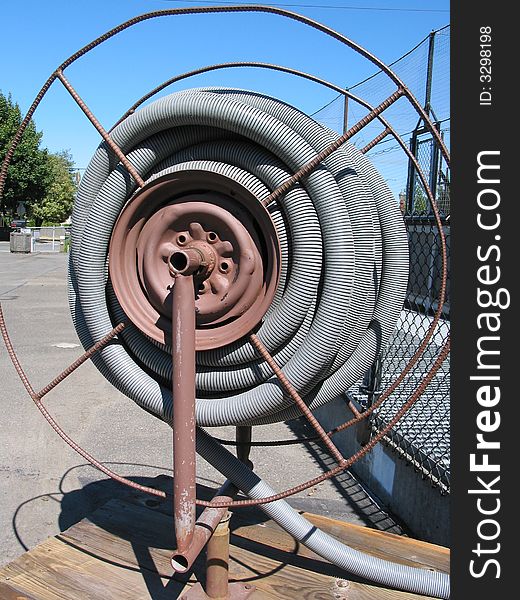 Gray plastic pipe is coiled on a reel at a fish hatchery. Gray plastic pipe is coiled on a reel at a fish hatchery.