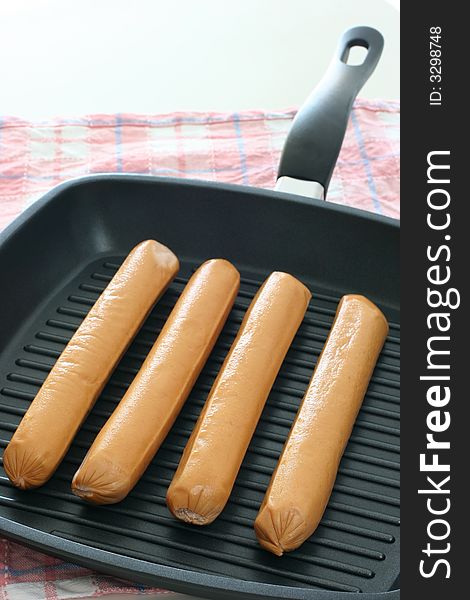 Large eight inch frankfurters on a grill pan for trying. Large eight inch frankfurters on a grill pan for trying