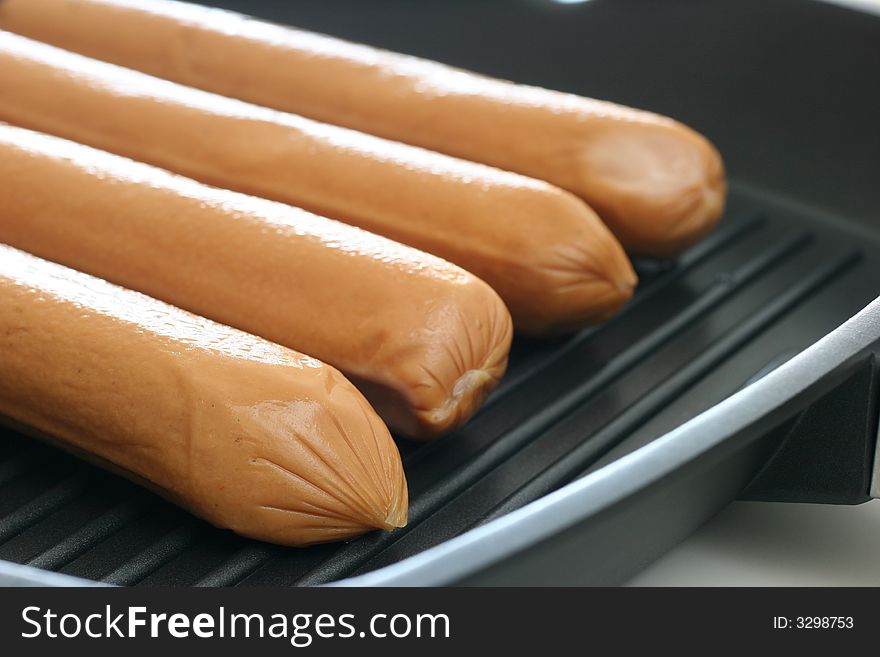 Large eight inch frankfurters on a grill pan for trying. Large eight inch frankfurters on a grill pan for trying