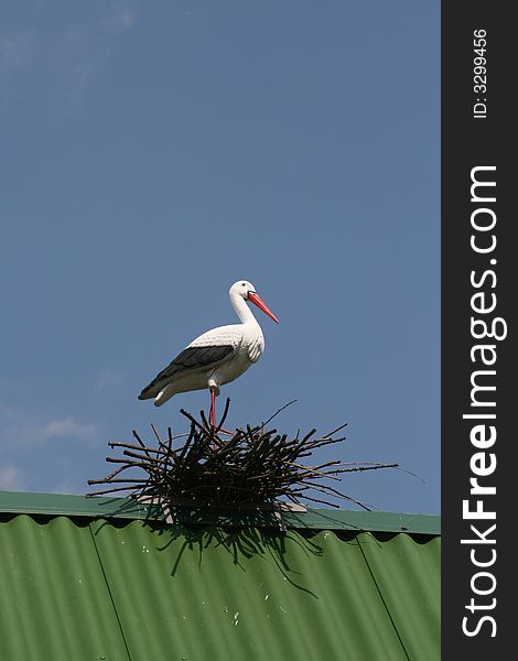 Decorative figure stork on nest on a roof