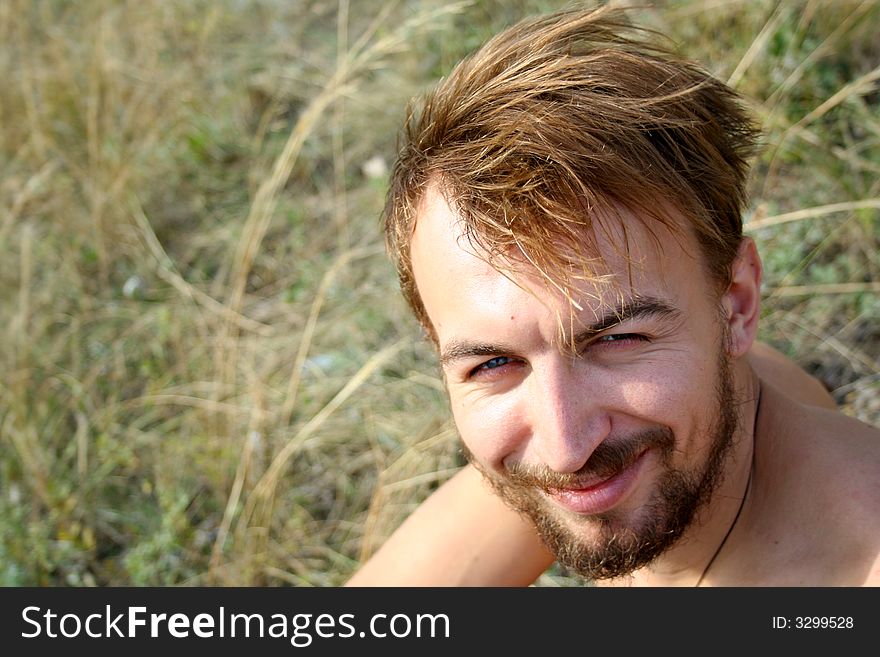 Young handsome man looks straight at the camera and smiles. Young handsome man looks straight at the camera and smiles.