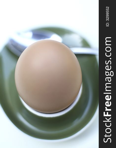 A single Boiled egg in an eggcup against a white background. A single Boiled egg in an eggcup against a white background