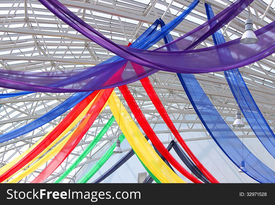 Decorative colored veils hanging from the ceiling metal structure