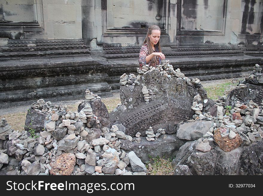 Girl sitting near the ancient walls of the temple. Girl sitting near the ancient walls of the temple