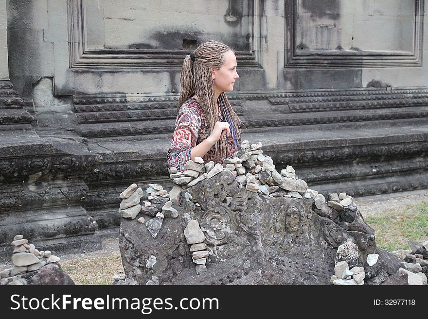 Girl sitting near the ancient walls of the temple. Girl sitting near the ancient walls of the temple