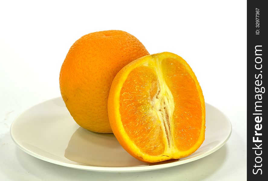 A single orange with a sliced orange. A single orange with a sliced orange