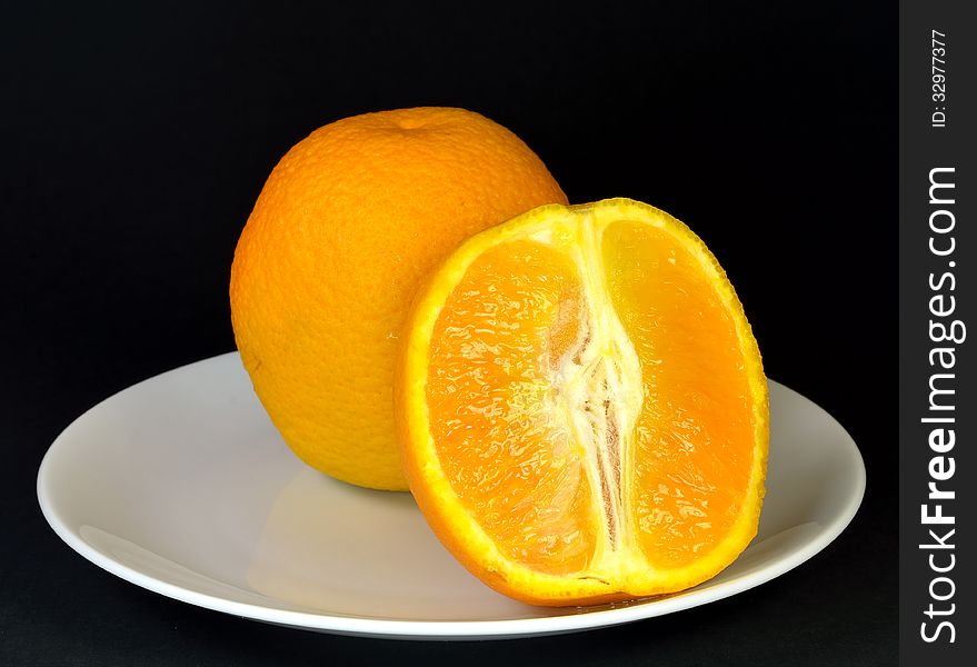 A single orange with a sliced orange. A single orange with a sliced orange.