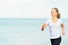 Young Woman Running On The Beach On The Coast Of The Sea Stock Image