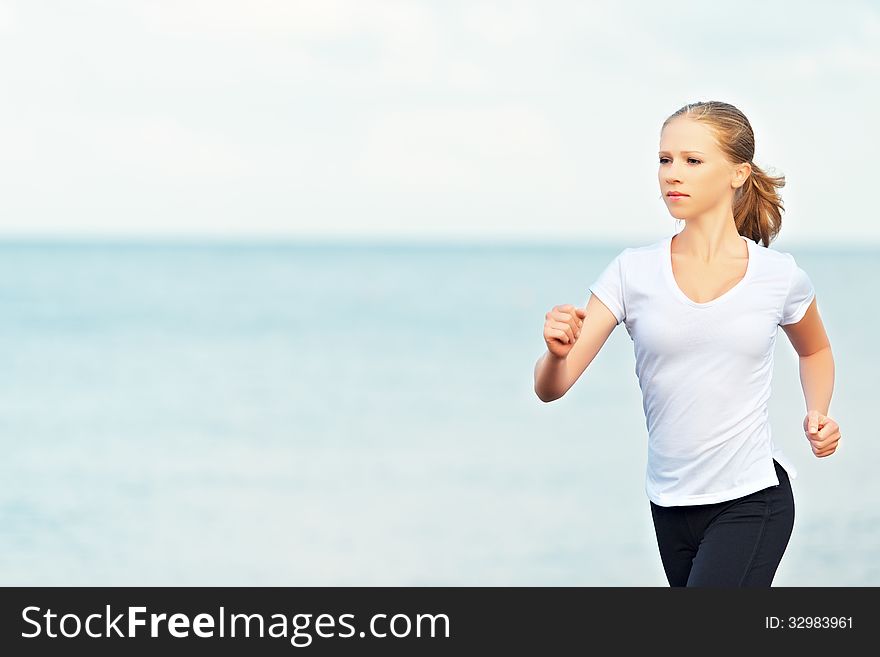 Morning jog. young woman running on the beach on the coast of the Sea