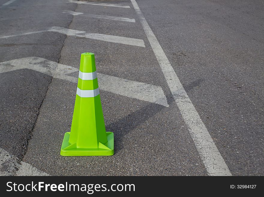 Green traffic cone. Placed on the road surface. Green traffic cone. Placed on the road surface