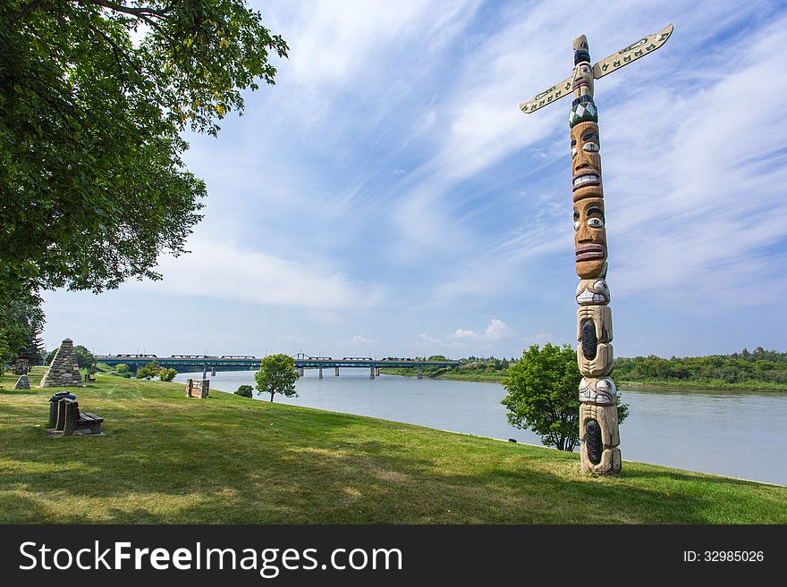 A totem pole in the park along the river. A totem pole in the park along the river