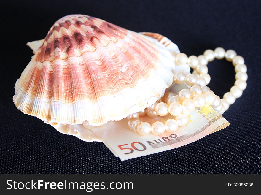 Luxury pearls in seashell and fifty euro on black background. Luxury pearls in seashell and fifty euro on black background.