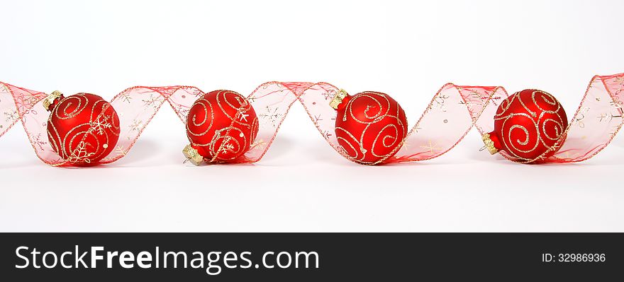 Red-golden baubles with the ribbon on the white background. Red-golden baubles with the ribbon on the white background