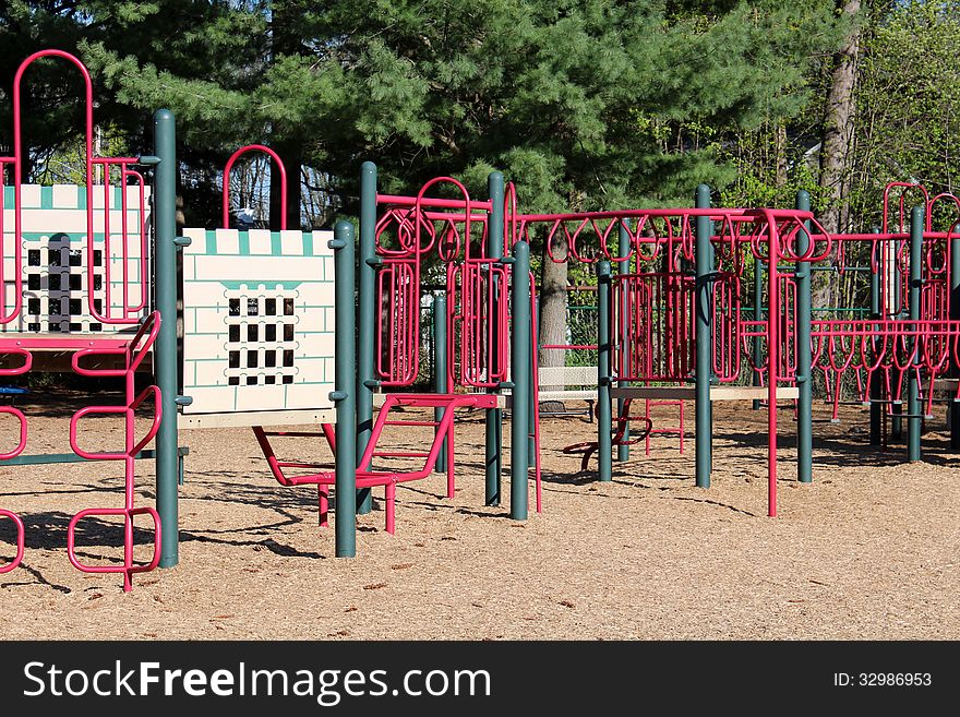 Modern playground made with colorful red and green piping tucked into wooded section of schoolyard. Modern playground made with colorful red and green piping tucked into wooded section of schoolyard.