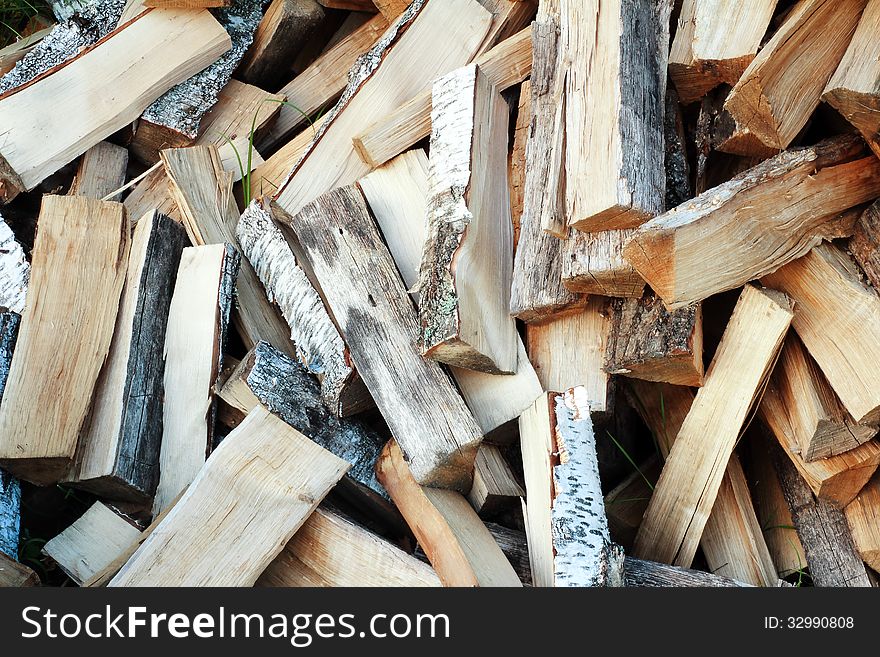 Firewood, prepared for the fireplace, lay a heap on the ground. Firewood, prepared for the fireplace, lay a heap on the ground.