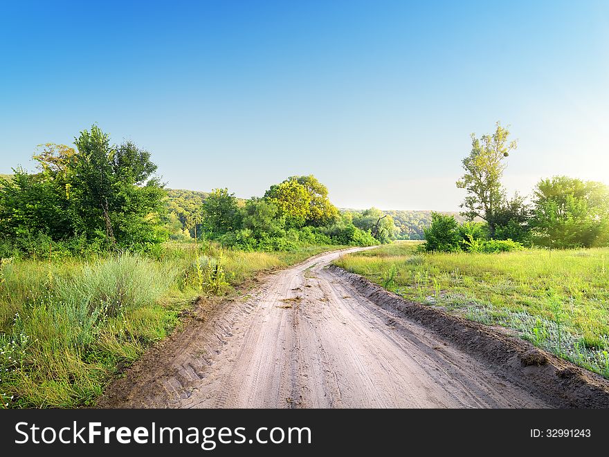 Winding road in a field at sunrise