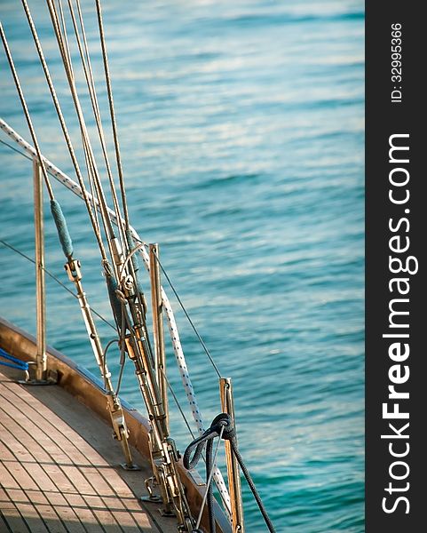 Sailing boat on sea background. Marine ropes and tackles for the rigging yacht. Wooden deck on the yacht with sea ropes.