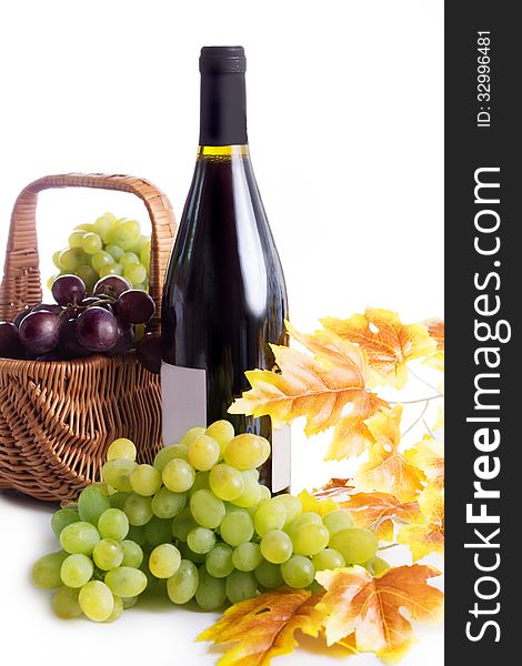 Ripe red and dark grapes and wine in basket isolated on white