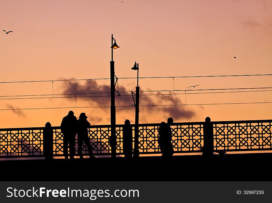 Galata Bridge in Istanbul at sunset with people on the bridge, profile view contr jour