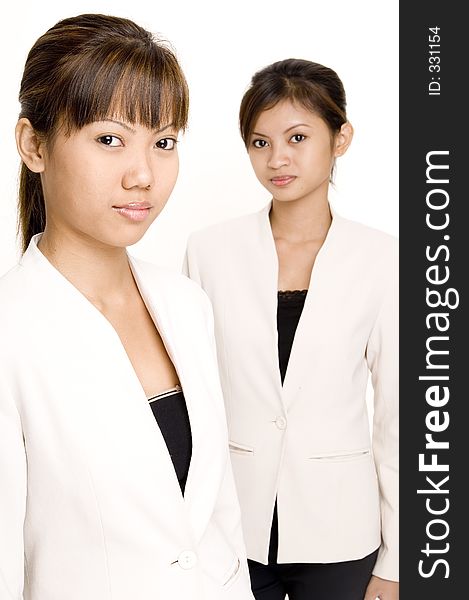 Two pretty asian women in matching business suits. Two pretty asian women in matching business suits