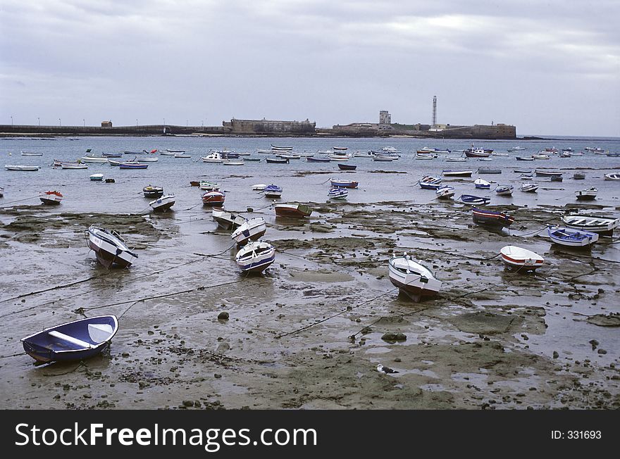 Boats in cadiz's harbor with low tide, Spain