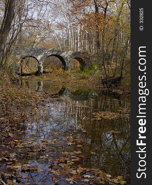 Stone bridge and creek with fall leaves. Stone bridge and creek with fall leaves