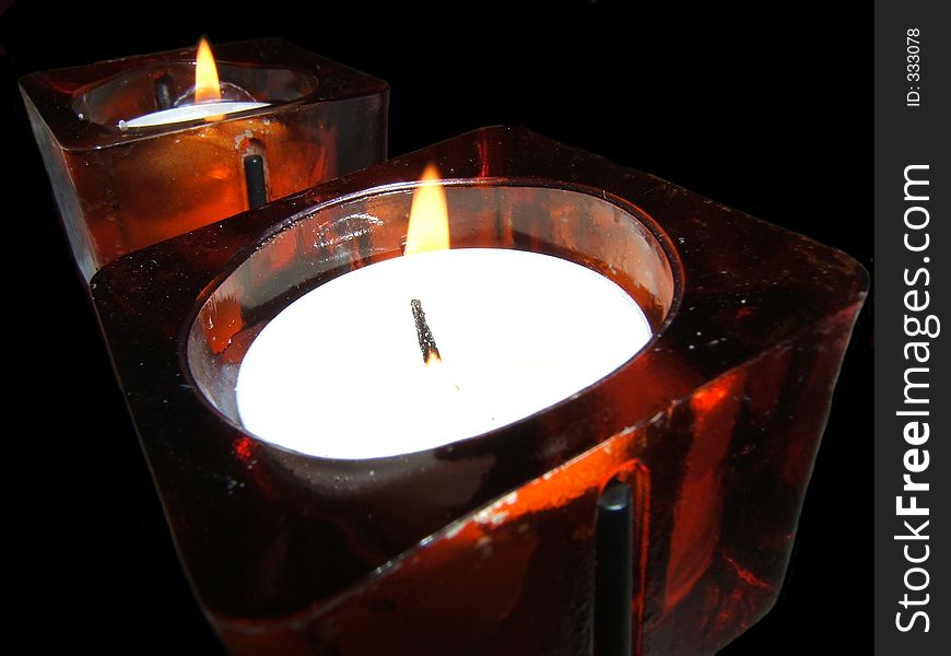 Two candles in red glass containers