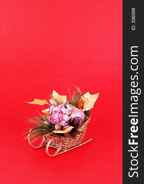Artificial flowers in a sleigh on red background with space for copy. Artificial flowers in a sleigh on red background with space for copy.