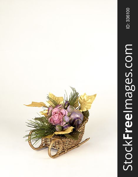 Artificial flowers in a sleigh on white background with space for copy. Artificial flowers in a sleigh on white background with space for copy.