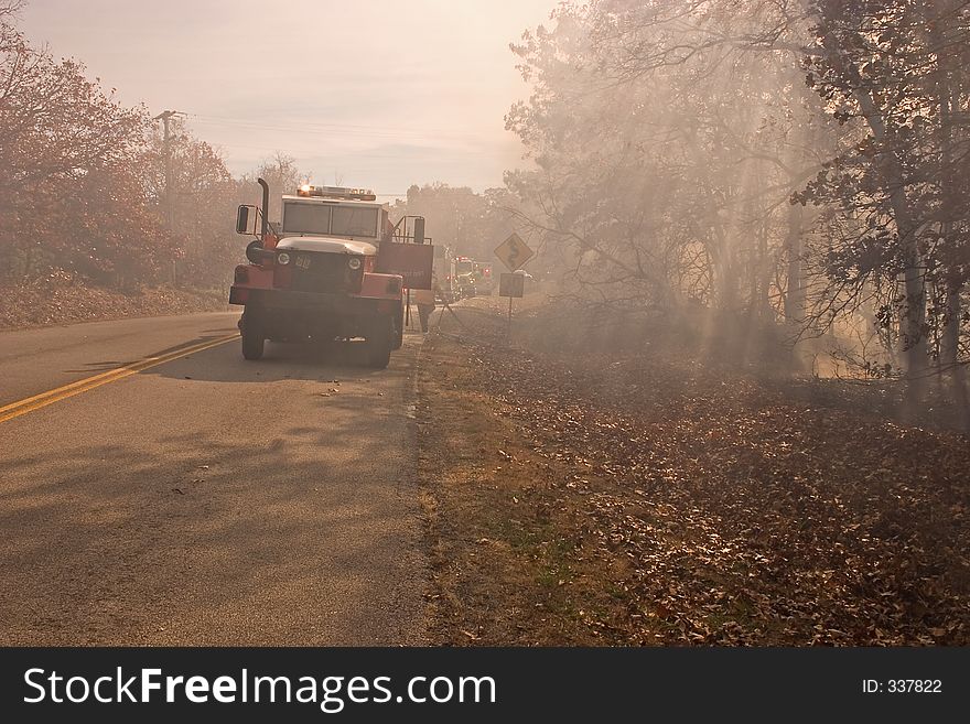 Fire tenders parked beside the highway while their crews fight a bush fire in the Ozark Mountains. Fire tenders parked beside the highway while their crews fight a bush fire in the Ozark Mountains