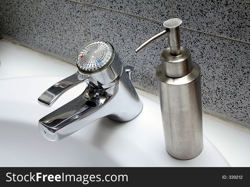 Water tap in the bathroom sink with soap dispenser. Water tap in the bathroom sink with soap dispenser