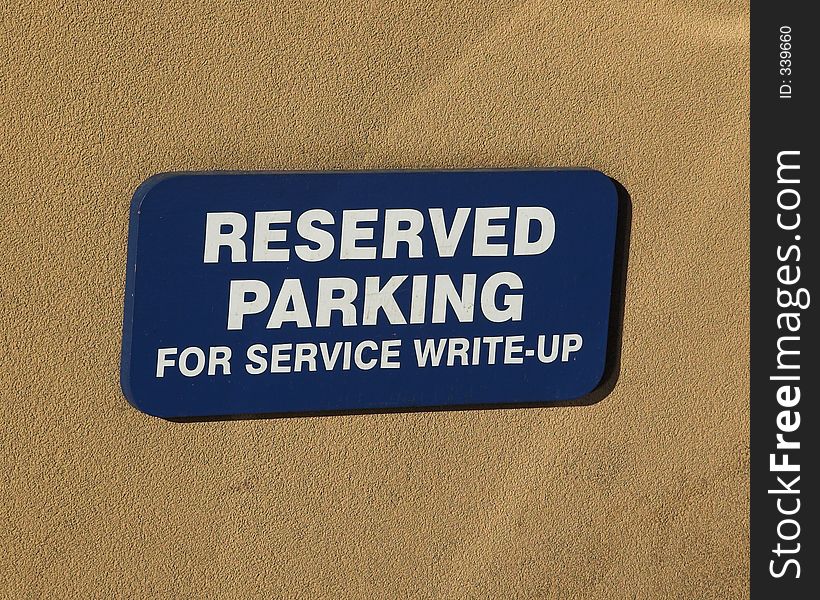 Closeup of reserved parkinging sign on tan background. Closeup of reserved parkinging sign on tan background