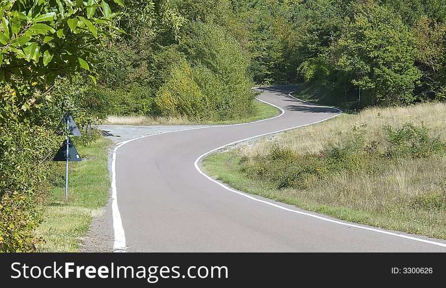 A winding road cutting its way through the countryside