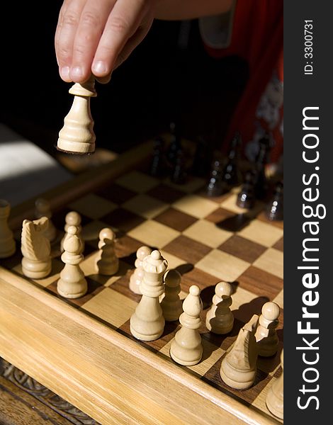 Young child playing chess on traditional wood chess set